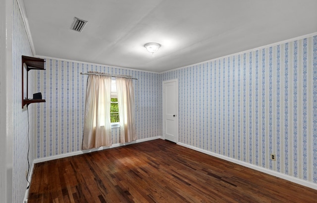 spare room with dark hardwood / wood-style floors and crown molding