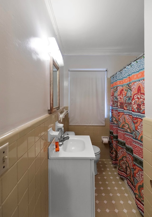 bathroom featuring vanity, toilet, tile walls, and ornamental molding