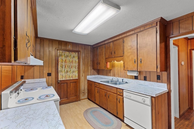 kitchen with a textured ceiling, white appliances, light hardwood / wood-style floors, and sink