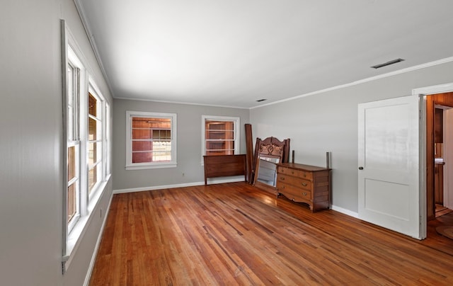 spare room featuring a wealth of natural light, crown molding, and hardwood / wood-style floors