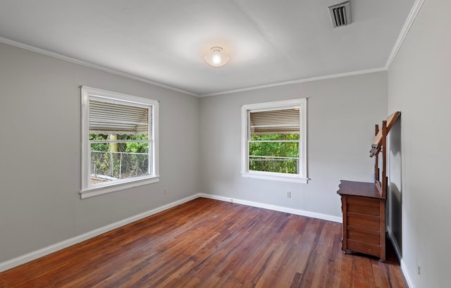 empty room with dark hardwood / wood-style flooring, a wealth of natural light, and crown molding