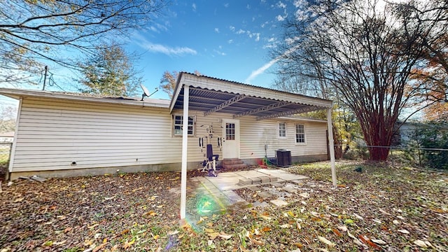 back of property with a patio and central AC