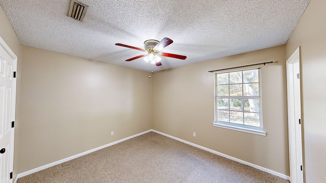 carpeted empty room with ceiling fan and a textured ceiling