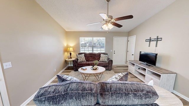 living room featuring a textured ceiling, ceiling fan, wood-type flooring, and lofted ceiling