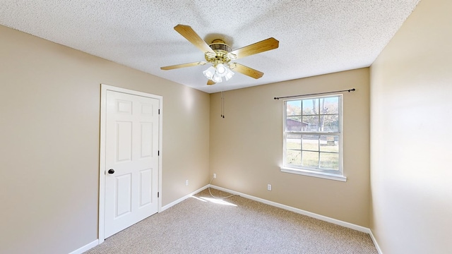 spare room featuring a textured ceiling, carpet floors, and ceiling fan