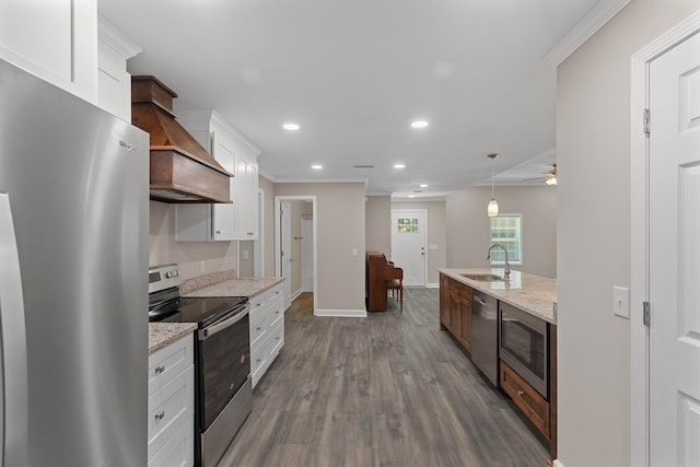 kitchen with sink, white cabinets, pendant lighting, and appliances with stainless steel finishes