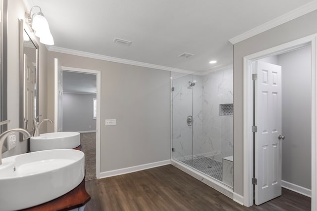 bathroom featuring vanity, hardwood / wood-style flooring, a shower with shower door, and ornamental molding