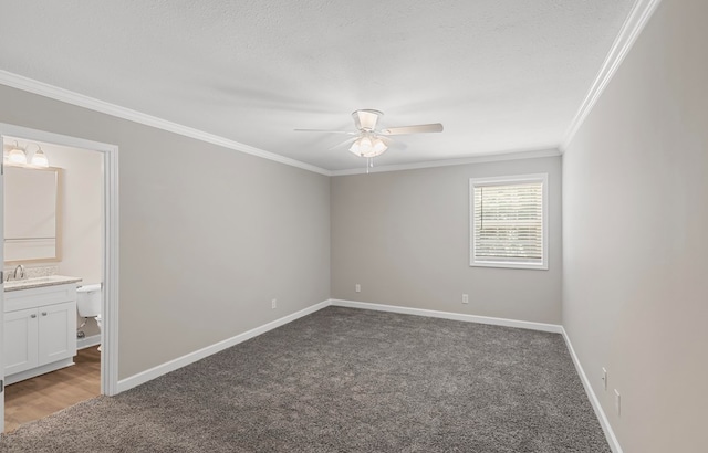 empty room with crown molding, a textured ceiling, and dark colored carpet