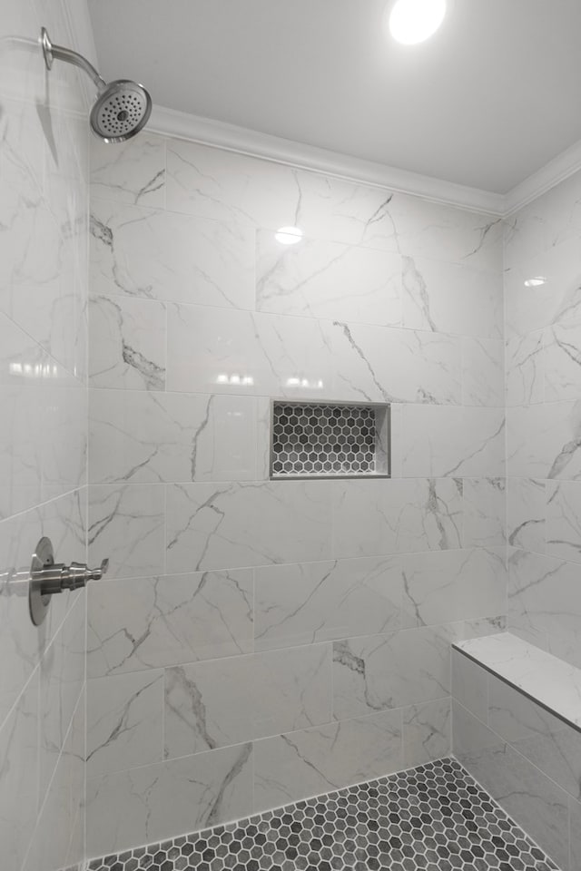 bathroom featuring tiled shower and crown molding