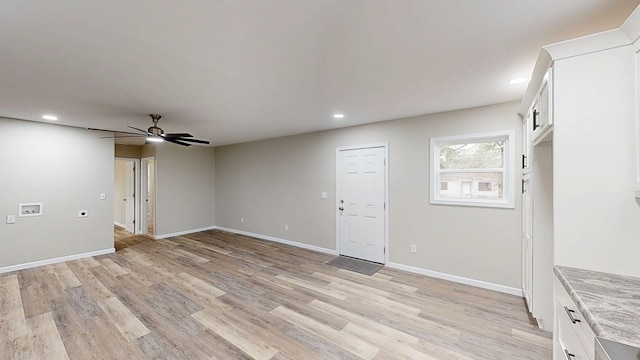 interior space featuring light wood finished floors, baseboards, a ceiling fan, and recessed lighting