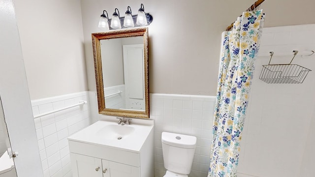 bathroom featuring vanity, toilet, and tile walls