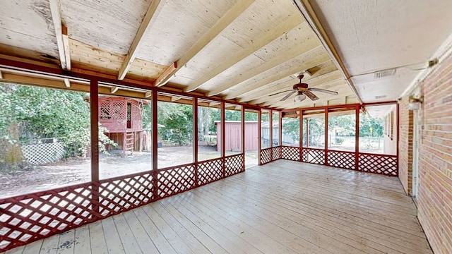 unfurnished sunroom with beamed ceiling and ceiling fan