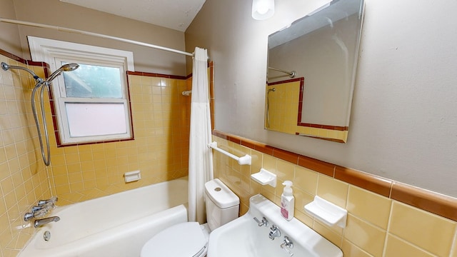 bathroom with tile walls, shower / bath combo, and toilet