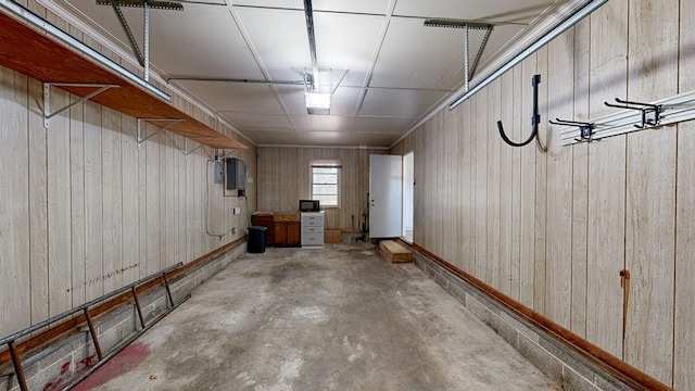 basement with wood walls and electric panel