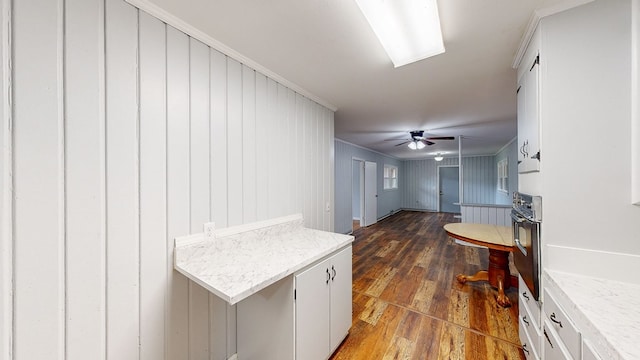 interior space featuring wooden walls, dark hardwood / wood-style flooring, and ornamental molding