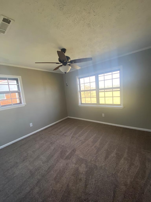 spare room with plenty of natural light, dark carpet, and ornamental molding