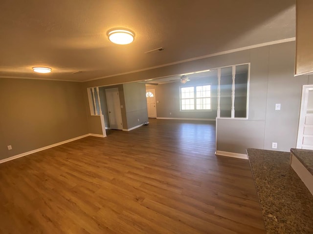 unfurnished room with ceiling fan, dark wood-type flooring, and ornamental molding