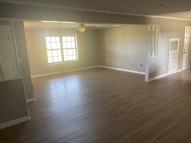 empty room with ceiling fan, dark hardwood / wood-style floors, and ornamental molding