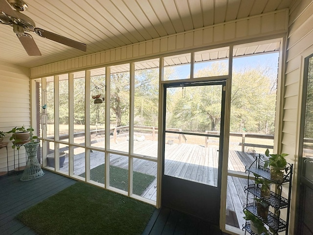 unfurnished sunroom featuring wood ceiling and ceiling fan