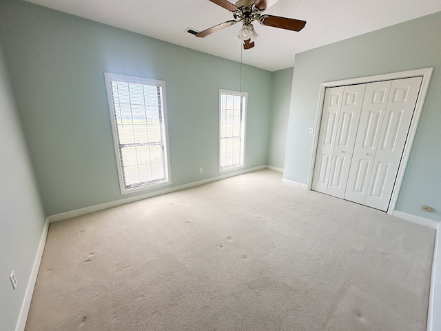 unfurnished bedroom with a closet, baseboards, carpet, and a ceiling fan