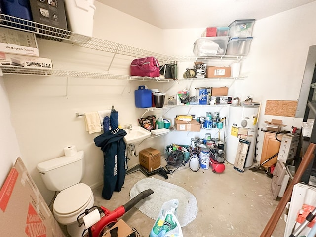 storage area featuring water heater and a sink