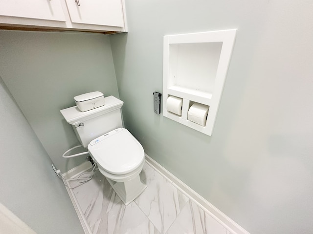 bathroom featuring baseboards, toilet, and marble finish floor