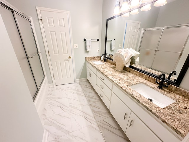 full bathroom featuring a stall shower, baseboards, marble finish floor, and a sink