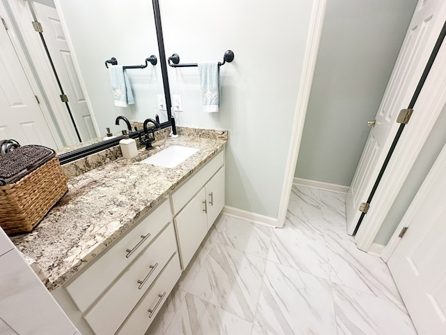 bathroom featuring vanity, baseboards, and marble finish floor