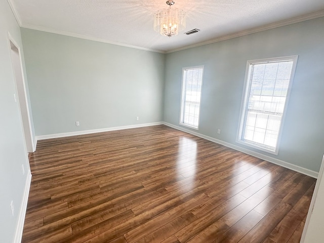 unfurnished room featuring dark wood finished floors, a chandelier, baseboards, and ornamental molding