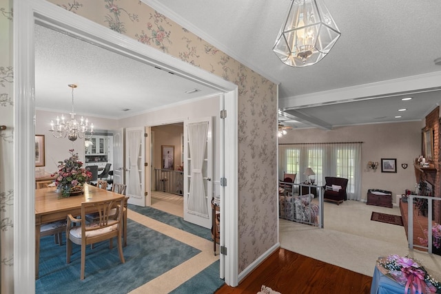 1764 John D Odom Rd, Dothan, AL 36303 - carpeted dining room featuring a chandelier, ornamental molding, a textured ceiling, wood finished floors, and wallpapered walls