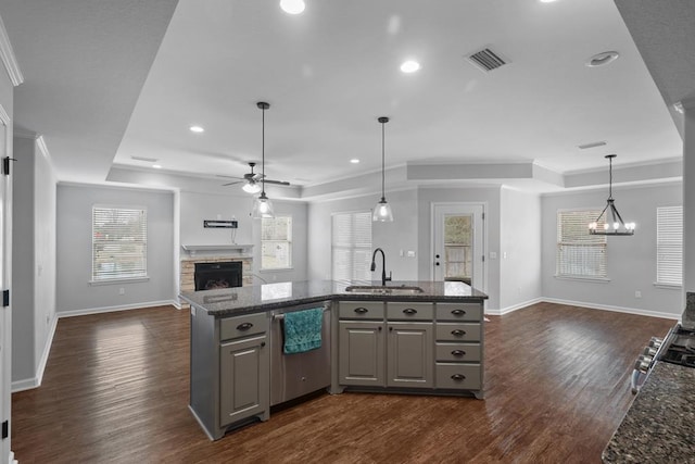 kitchen with open floor plan, a tray ceiling, a sink, and gray cabinetry