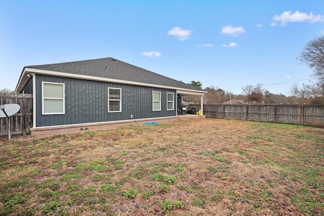 rear view of house with a fenced backyard and a lawn