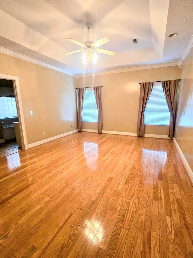2230 W County Road 16, Headland, AL 36345 - unfurnished room with light wood finished floors, a tray ceiling, a ceiling fan, baseboards, and ornamental molding