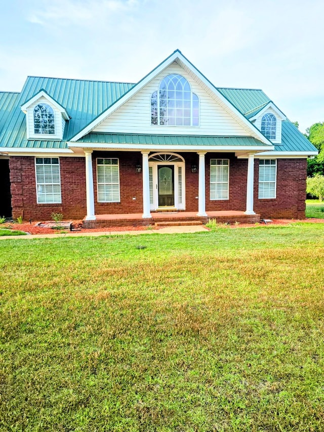2230 W County Road 16, Headland, AL 36345 - view of front of home featuring brick siding, a porch, a front lawn, and metal roof