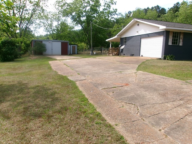 5559 N County Road 69, Newton, AL 36352 - view of yard featuring driveway, an outbuilding, view of scattered trees, and a garage