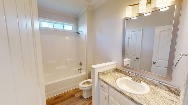 full bathroom featuring washtub / shower combination, toilet, hardwood / wood-style flooring, vanity, and ornamental molding