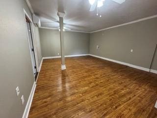finished below grade area with baseboards, wood finished floors, and crown molding