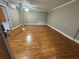 finished basement with wood finished floors, ceiling fan, crown molding, and baseboards