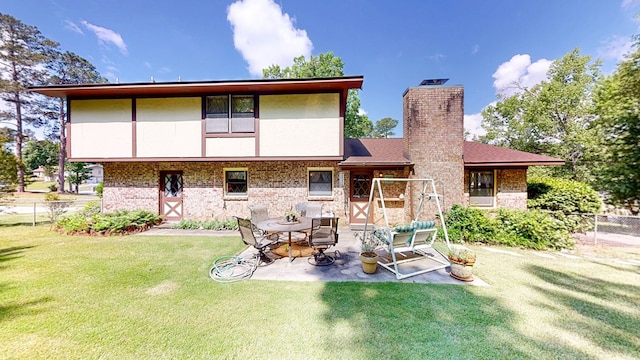 back of house with brick siding, a chimney, and a patio area
