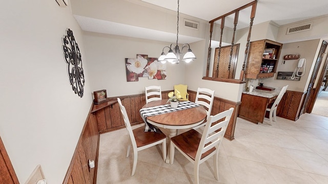 dining room featuring a chandelier, wainscoting, and light tile patterned flooring