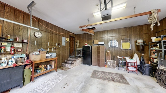 garage with freestanding refrigerator, wood walls, and a garage door opener