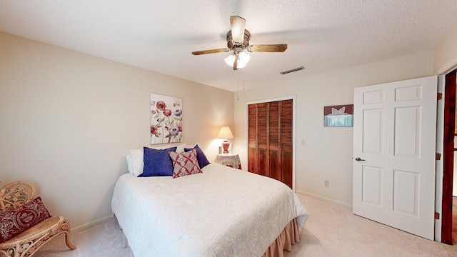 bedroom featuring light carpet, a closet, a ceiling fan, and baseboards