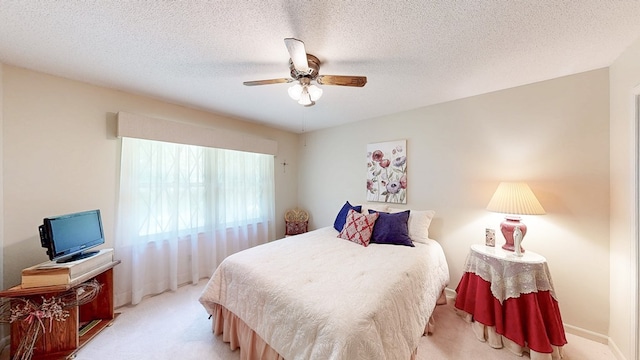 bedroom featuring carpet, a ceiling fan, and a textured ceiling