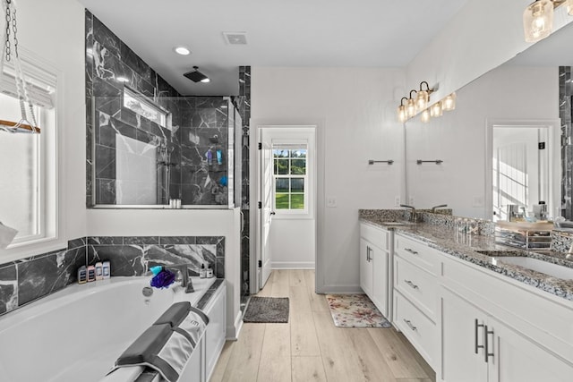 213 Archer Trl, Enterprise, AL 36351 - full bath featuring wood finished floors, a sink, a bath, and a stall shower
