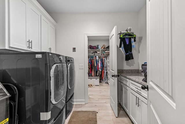 213 Archer Trl, Enterprise, AL 36351 - clothes washing area with washing machine and clothes dryer, light wood finished floors, and cabinet space