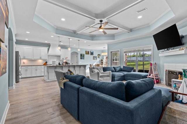 213 Archer Trl, Enterprise, AL 36351 - living area featuring crown molding, a tiled fireplace, a ceiling fan, light wood-type flooring, and visible vents