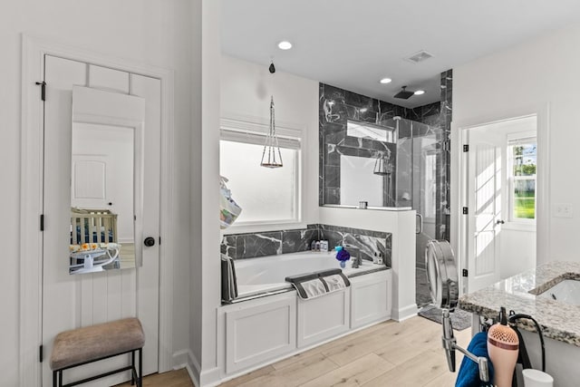 213 Archer Trl, Enterprise, AL 36351 - full bathroom featuring wood finished floors, a stall shower, a garden tub, and visible vents