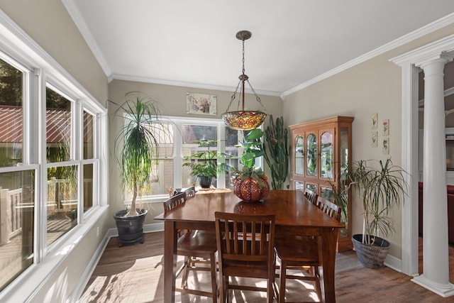 dining space with wood-type flooring, ornamental molding, and ornate columns