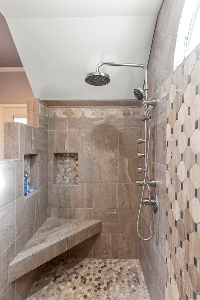 bathroom featuring crown molding and tiled shower