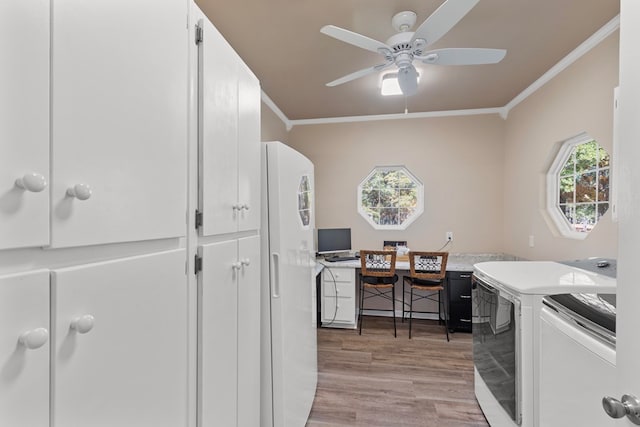 washroom featuring ceiling fan, ornamental molding, light hardwood / wood-style floors, and washing machine and dryer